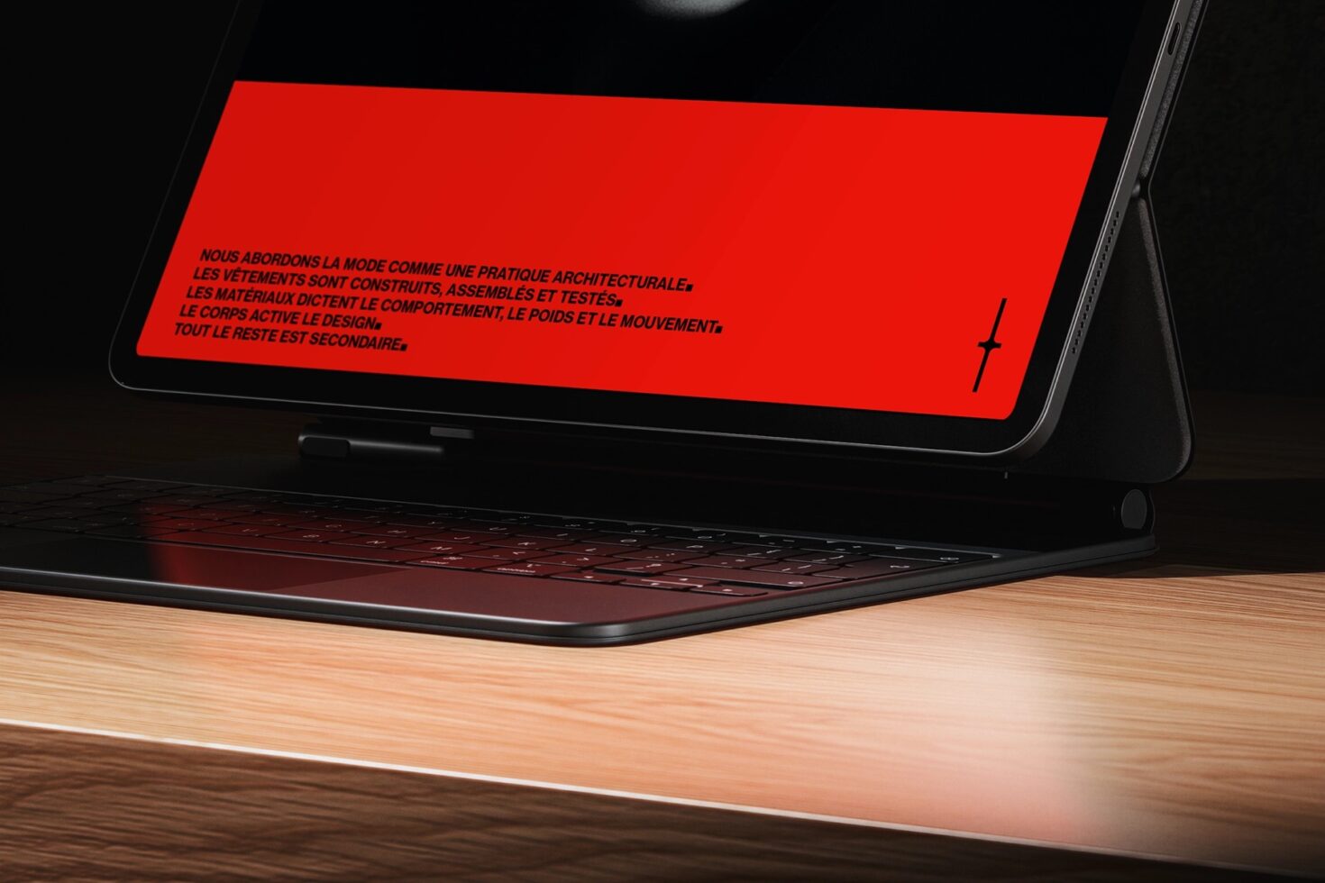 Laptop screen angled showing bold red banner with French text on wood desk