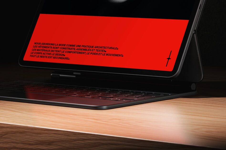 Laptop screen angled showing bold red banner with French text on wood desk