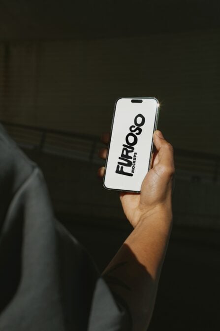 Hand displaying white iPhone screen with black Furioso Mockups text logo