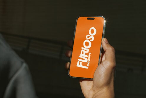 Orange iPhone in hand showing white Furioso Mockups logo on bright display
