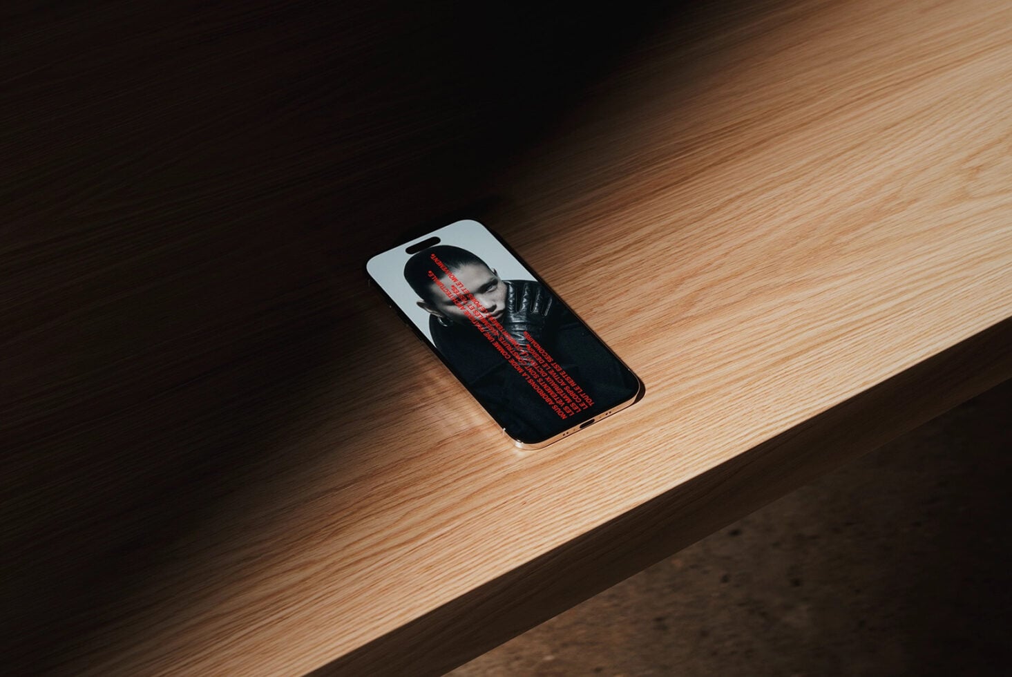 Phone mockup showing portrait photo with red text overlay on wooden floor