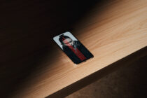 Phone mockup showing portrait photo with red text overlay on wooden floor