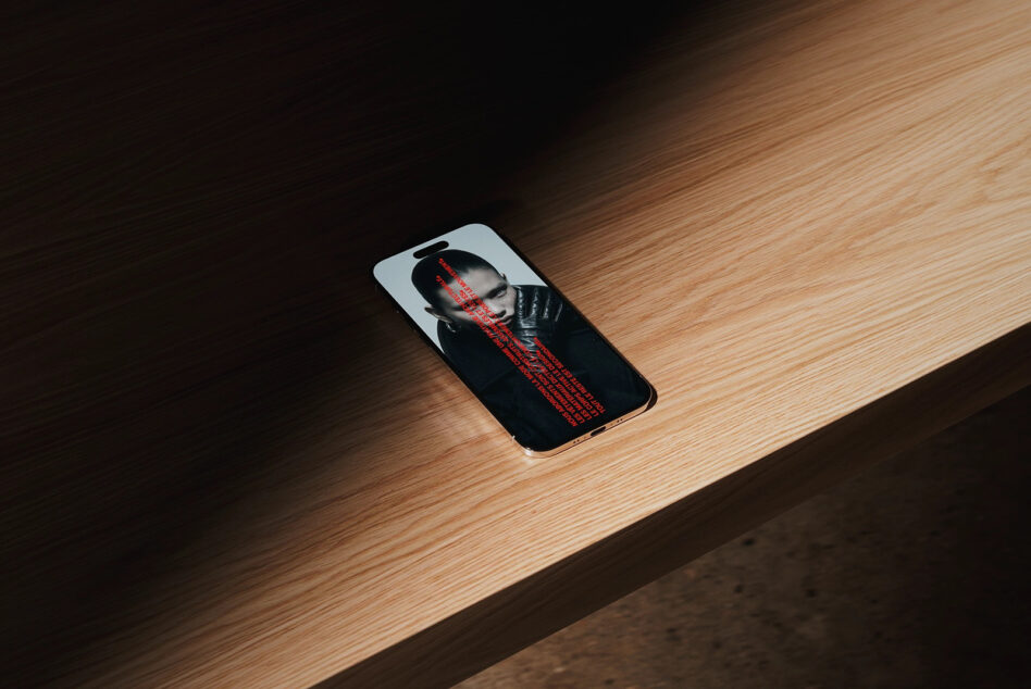 Phone mockup showing portrait photo with red text overlay on wooden floor