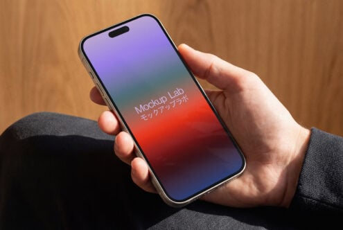 Hand holding phone showing purple to red gradient with notch