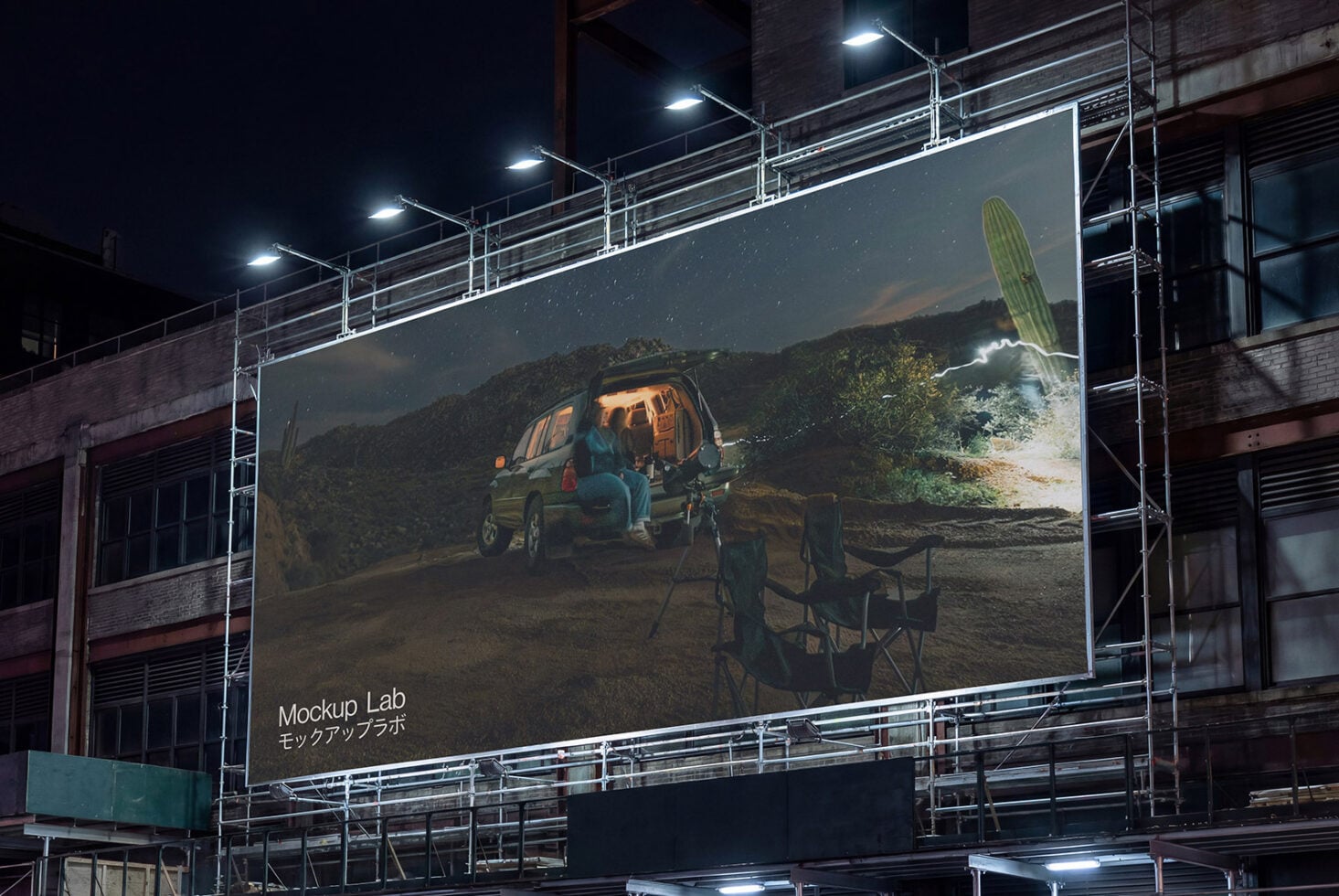 Large night billboard showing camping scene with van in mountains