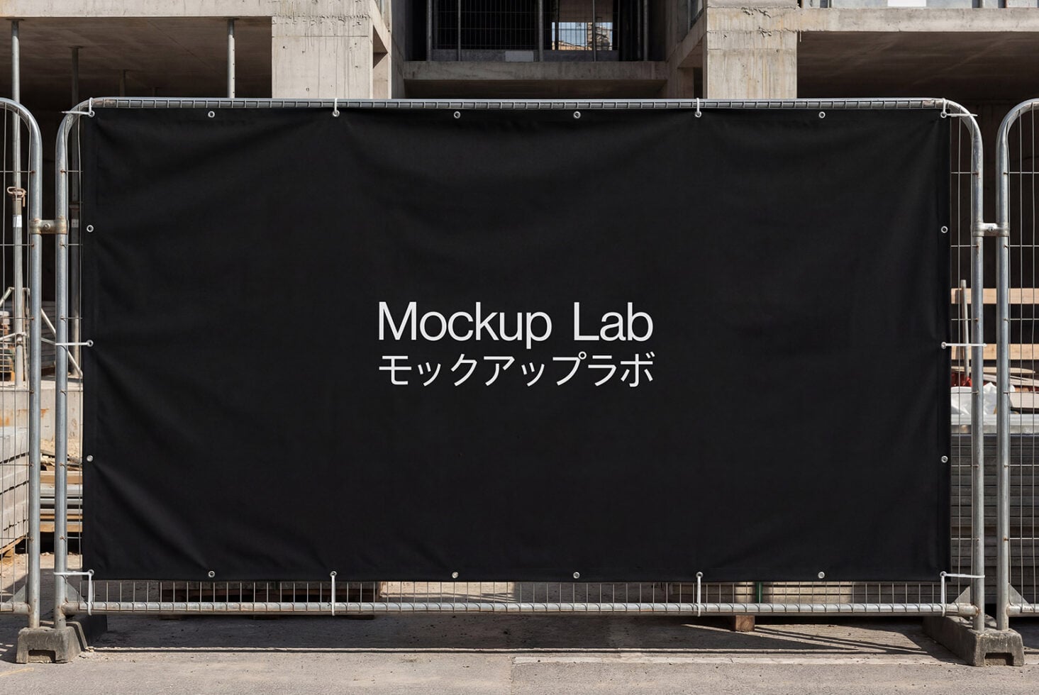 Black mesh fence banner with white Mockup Lab text on construction site