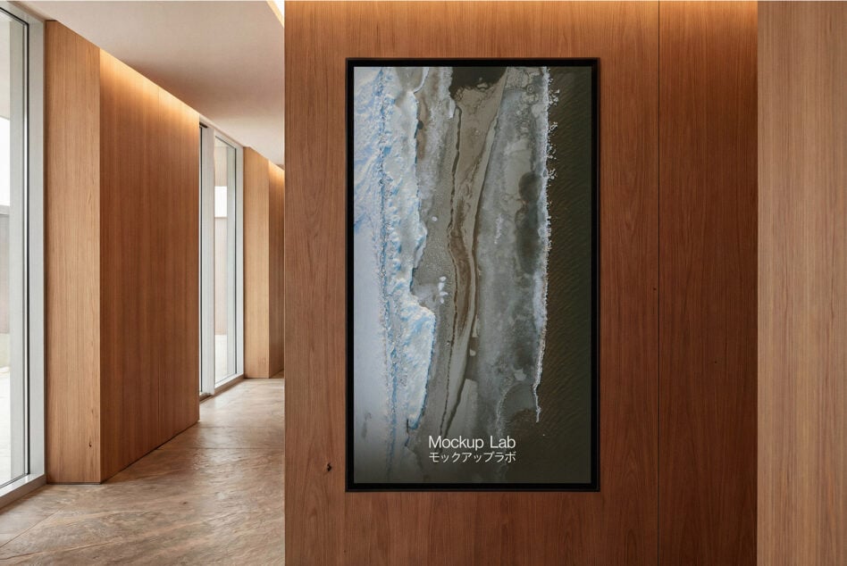 Vertical framed screen in hallway displaying aerial beach photography