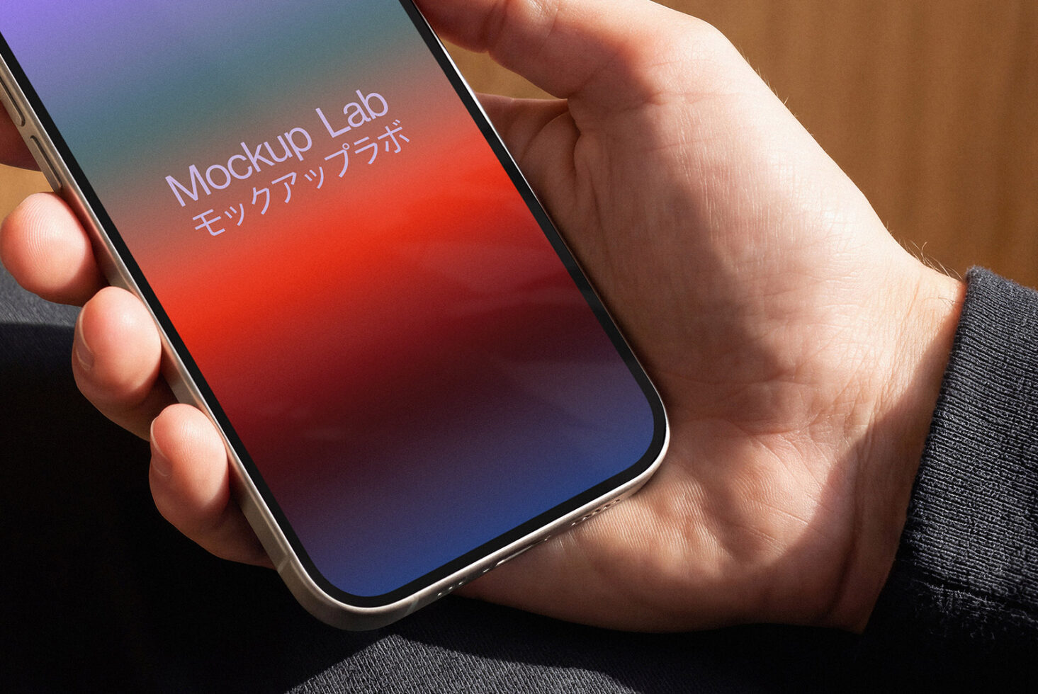 Hand holding phone with colorful gradient screen in natural light