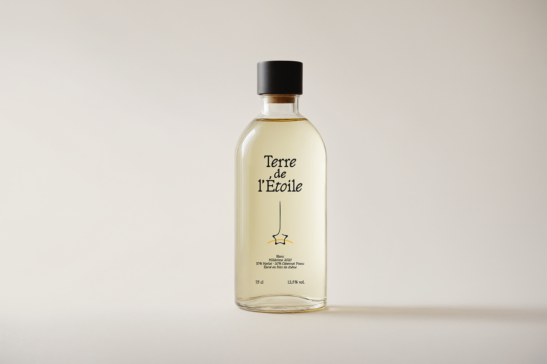 Glass wine bottle mockup with pale liquid inside labeled Terre de l'Etoile