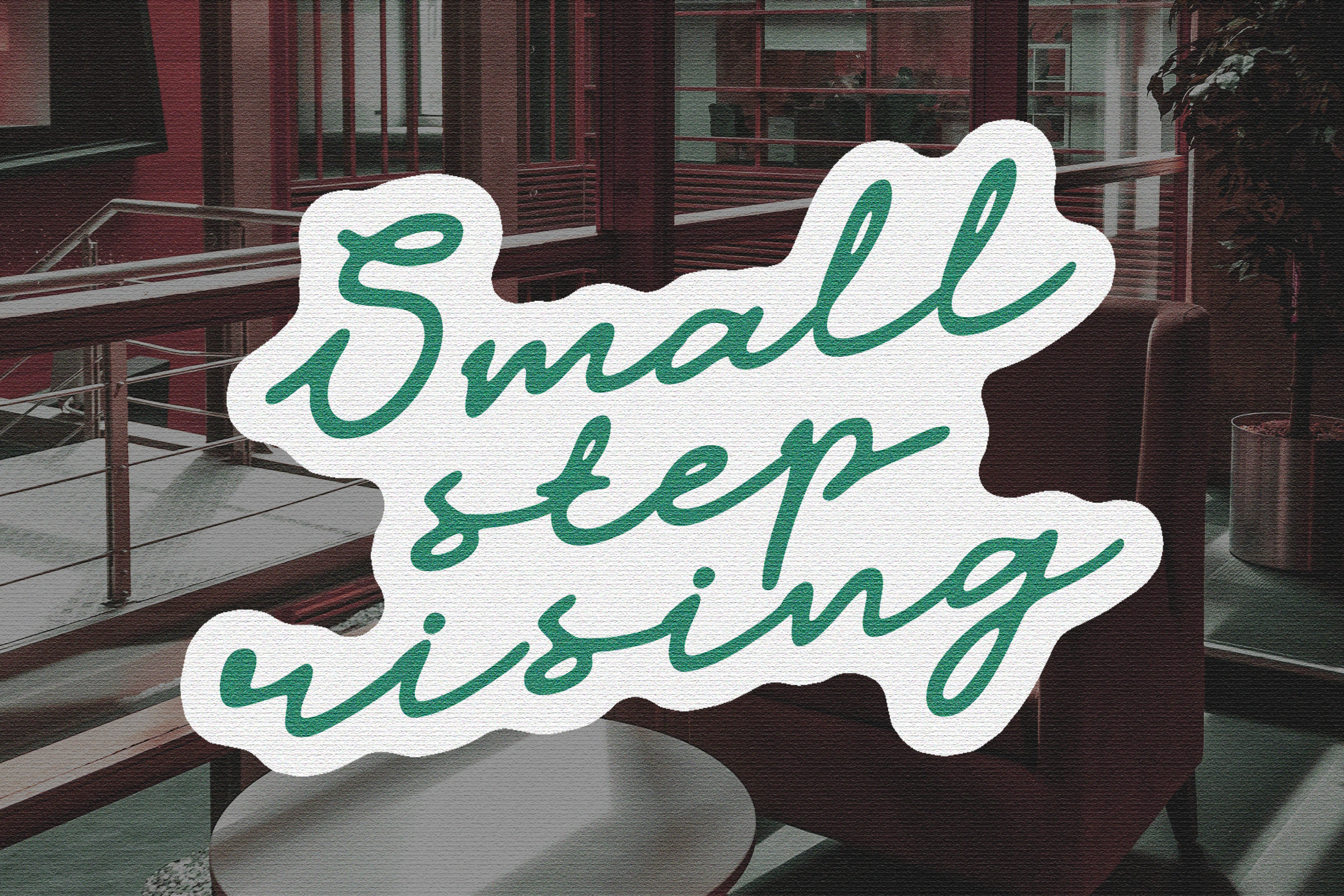 Handwritten calligraphy text Small step rising on textured paper background in a modern office setting. Perfect for graphics, templates, and mockups.