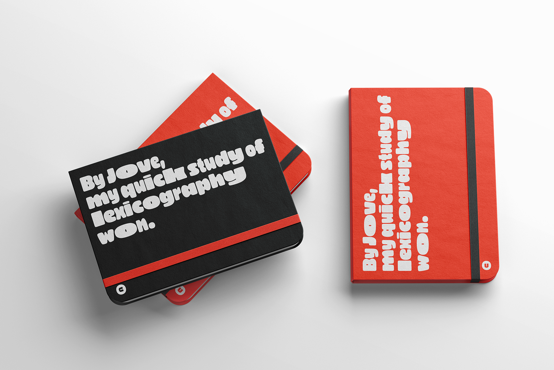 Two red notebooks with elastic bands, black cover on left with white text