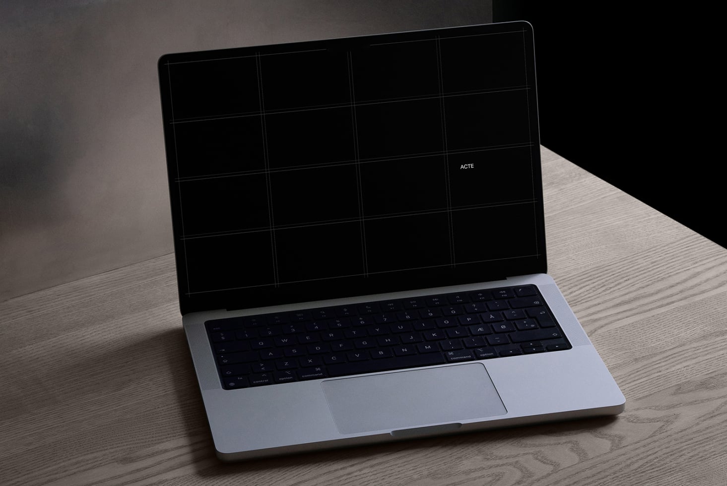 Silver laptop angled open with black screen, 4-column grid visible