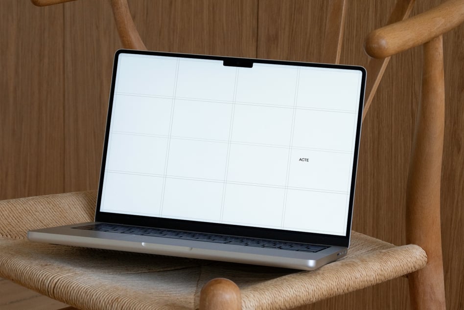 Laptop on wooden chair with white screen showing 4x3 grid layout