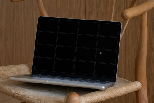 Laptop on wooden chair showing black screen with 4x3 grid pattern