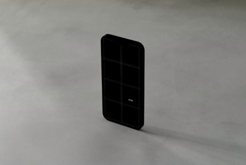 Black phone with dark grid display on light concrete background tilted
