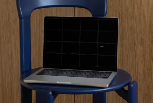 Laptop on blue chair showing dark screen with grid overlay