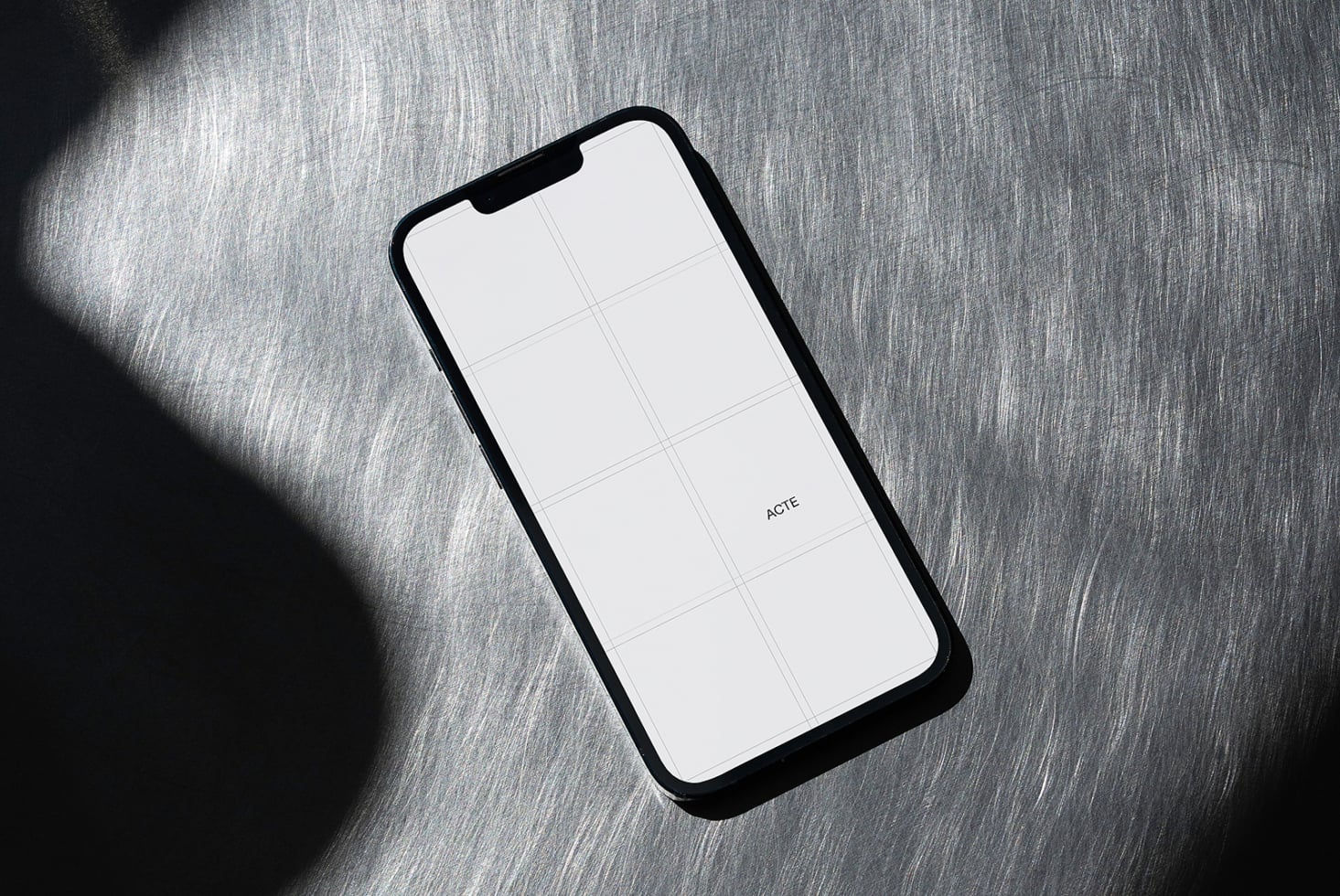 Black phone with white screen showing grid layout on gray fabric