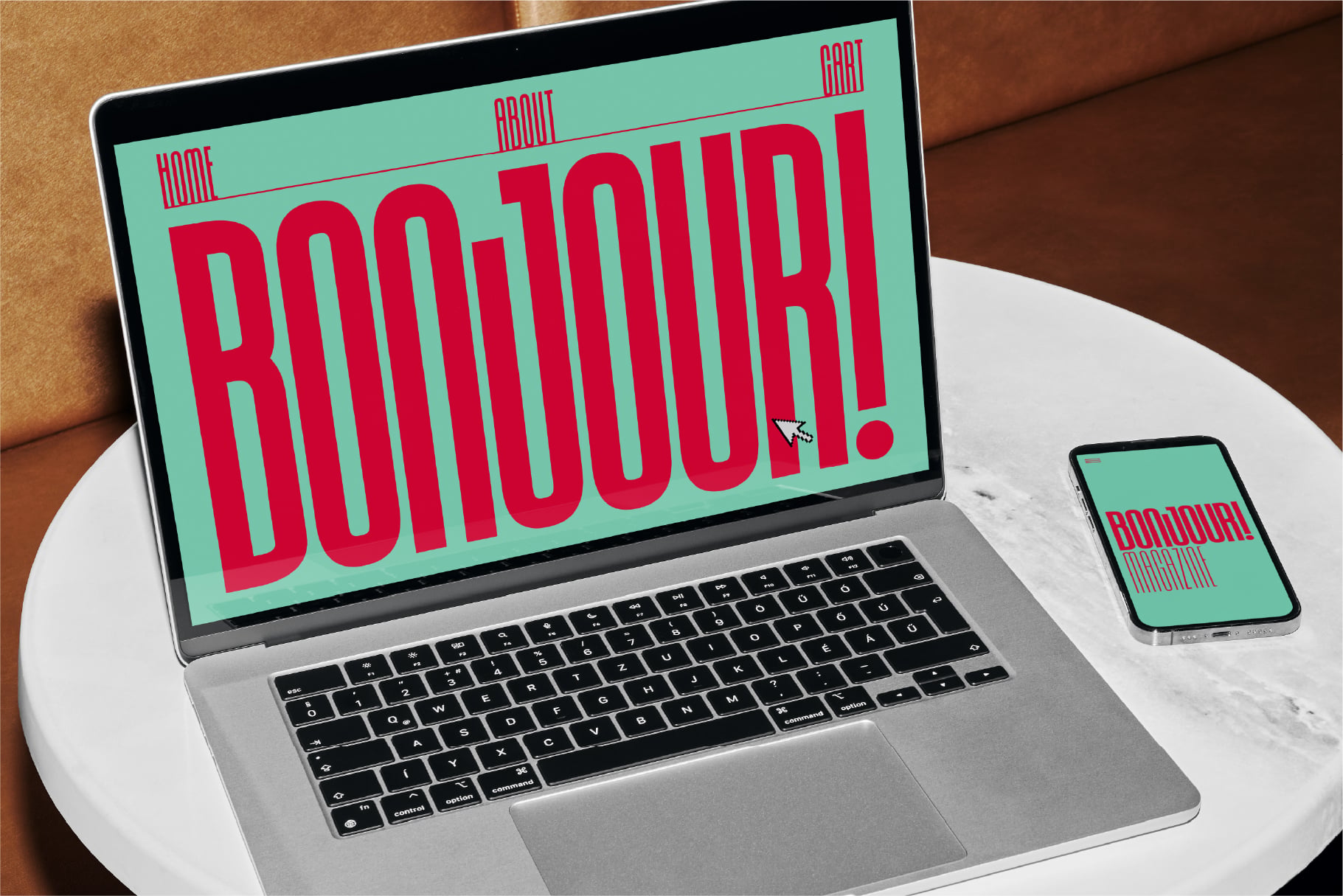 Laptop showing mint website with red striped text, phone beside on marble table