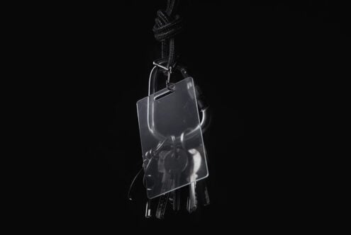 Clear acrylic keychain mockup with braided cord on dark backdrop