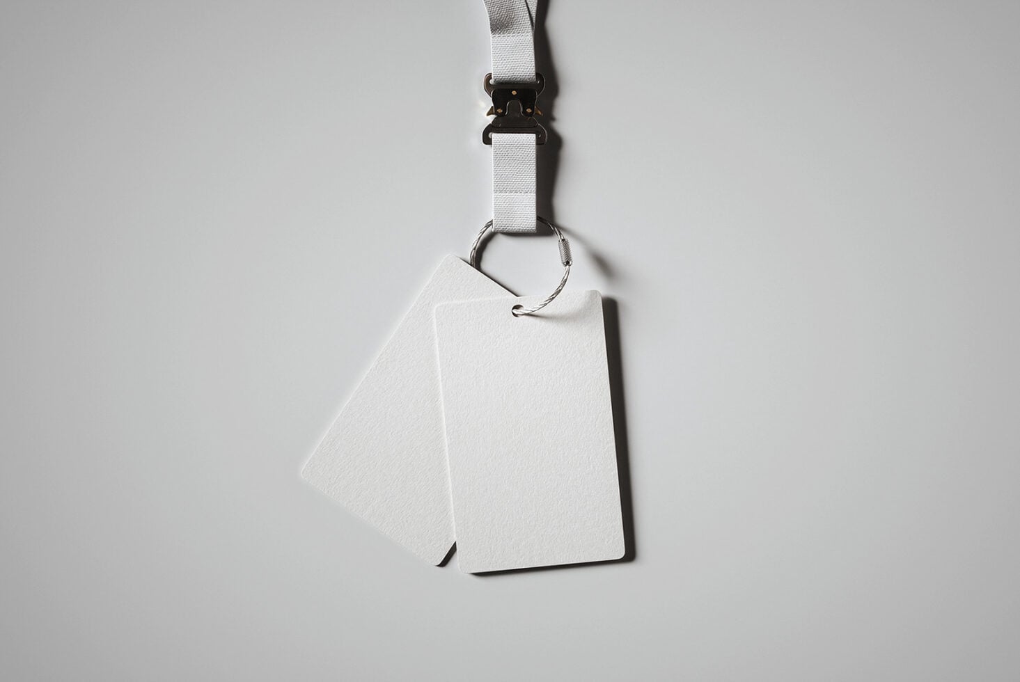 White lanyard with black clip holding blank white ID badge card