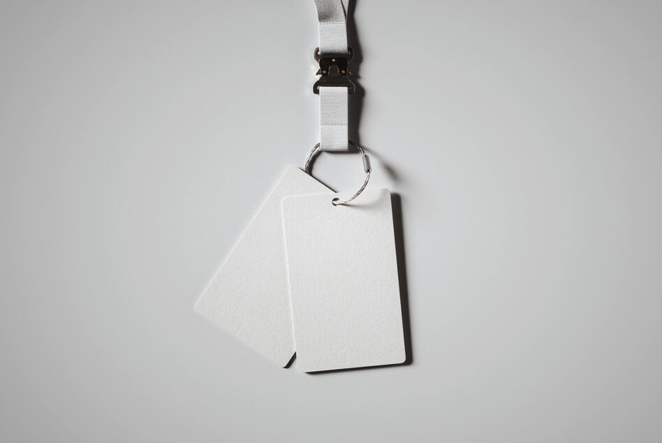 White lanyard with black clip holding blank white ID badge card