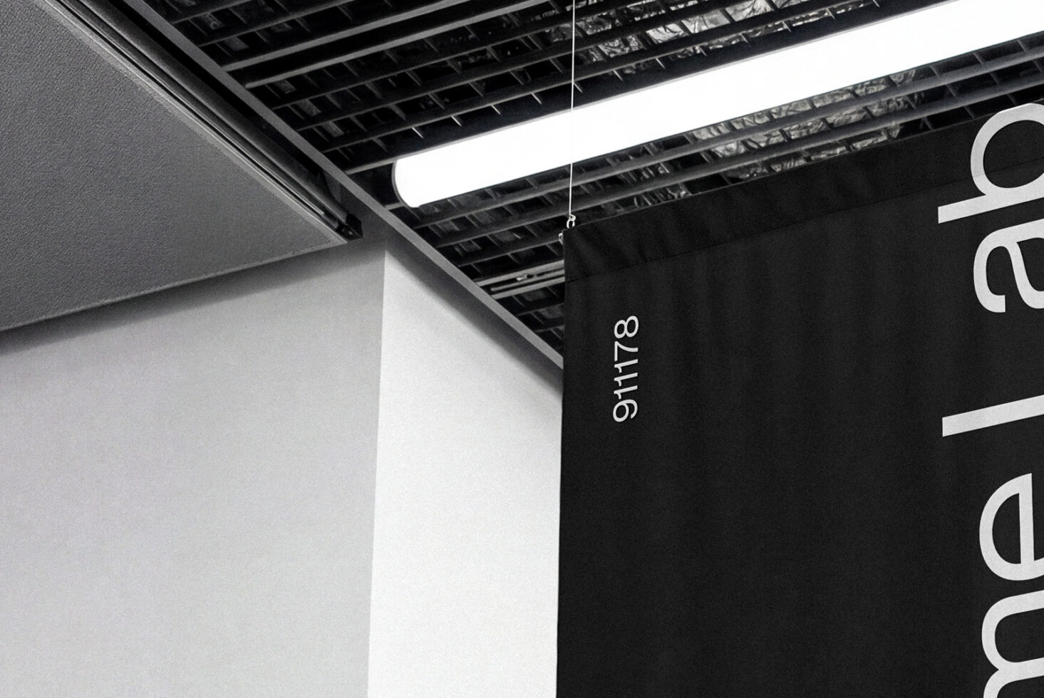 Hanging black banner with vertical white text in modern minimalist industrial space