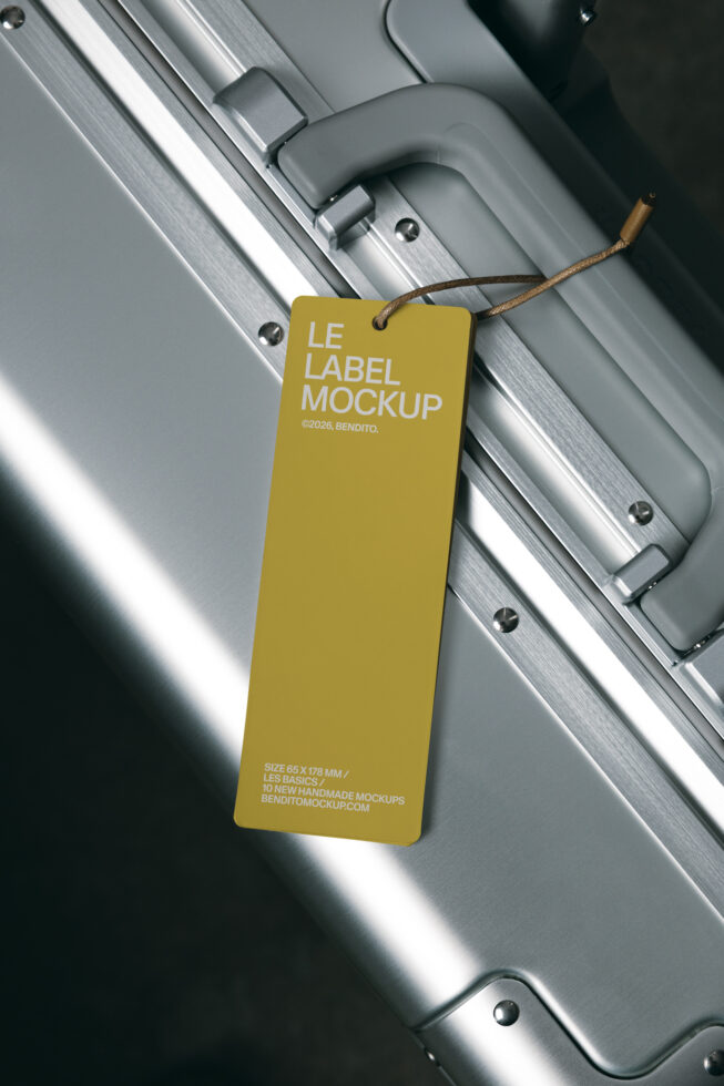 Yellow hang tag label mockup dangling from metallic suitcase handle with twine