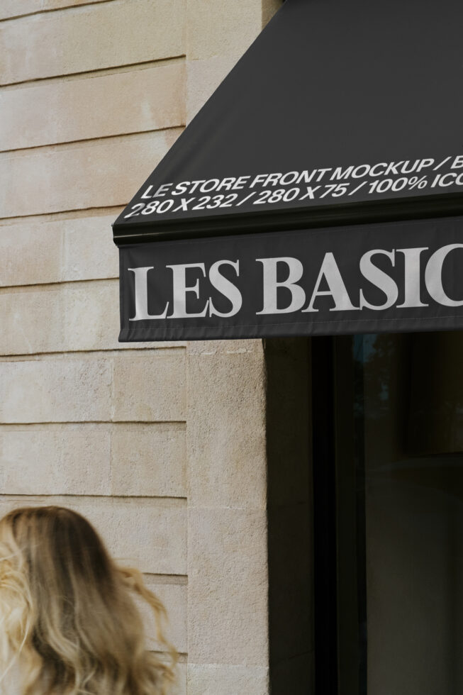 Black storefront awning with white serif text reading Les Basiq on brick building