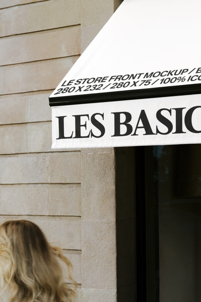 White storefront awning with black serif text reading Les Basiq on brick building