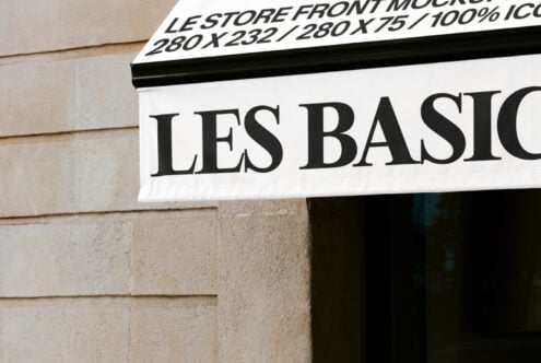 Close up of white awning with large black serif typography Les Basiq on facade
