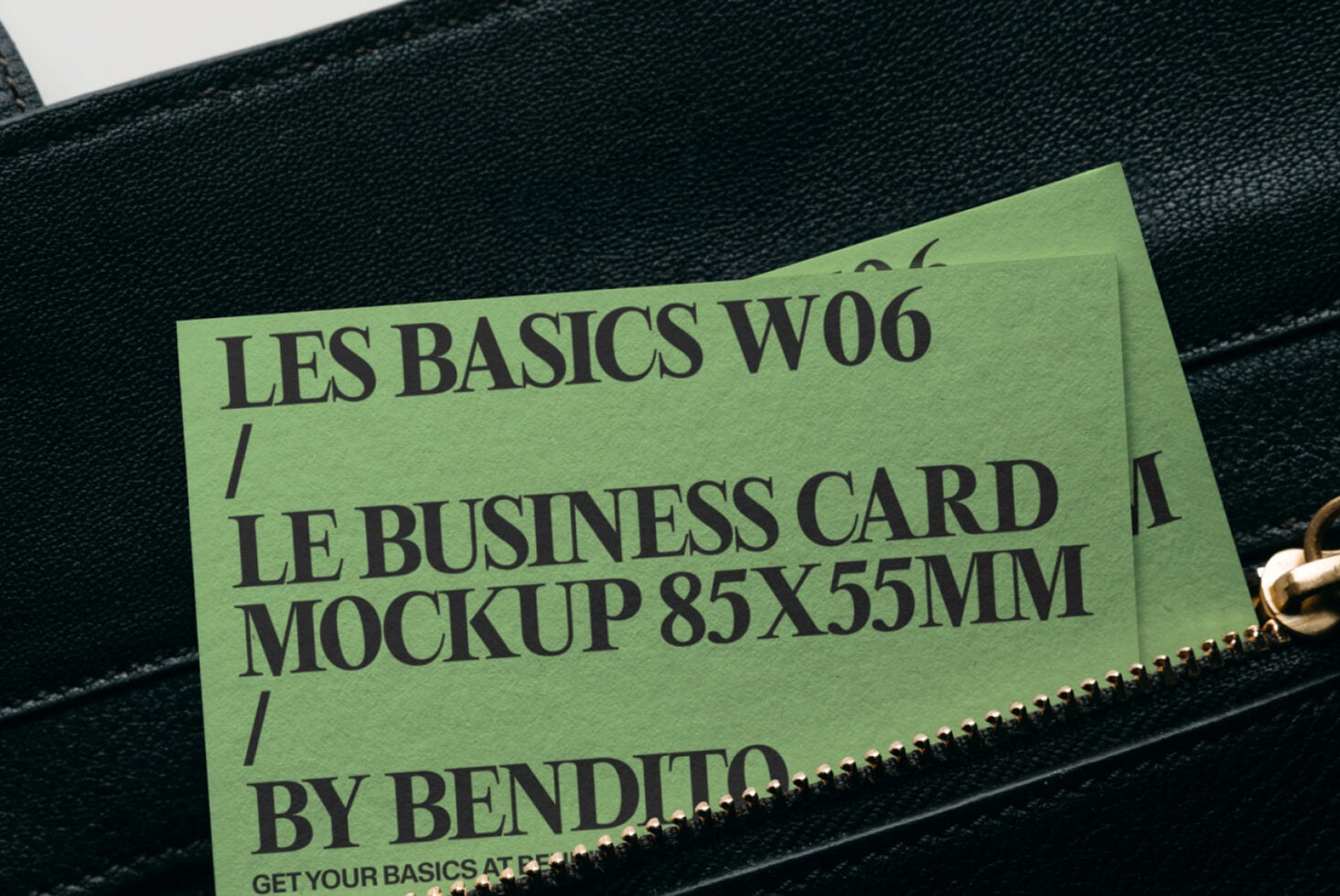 Lime business card mockup peeking from black leather bag with gold zipper