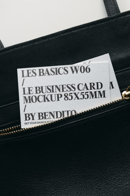 White business card mockup tucked into black leather bag pocket
