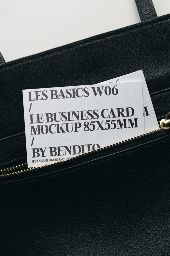 White business card mockup tucked into black leather bag pocket