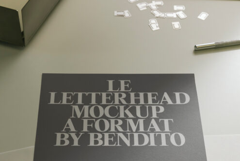 Dark letterhead mockup with serif typography on neutral desk with scattered business cards