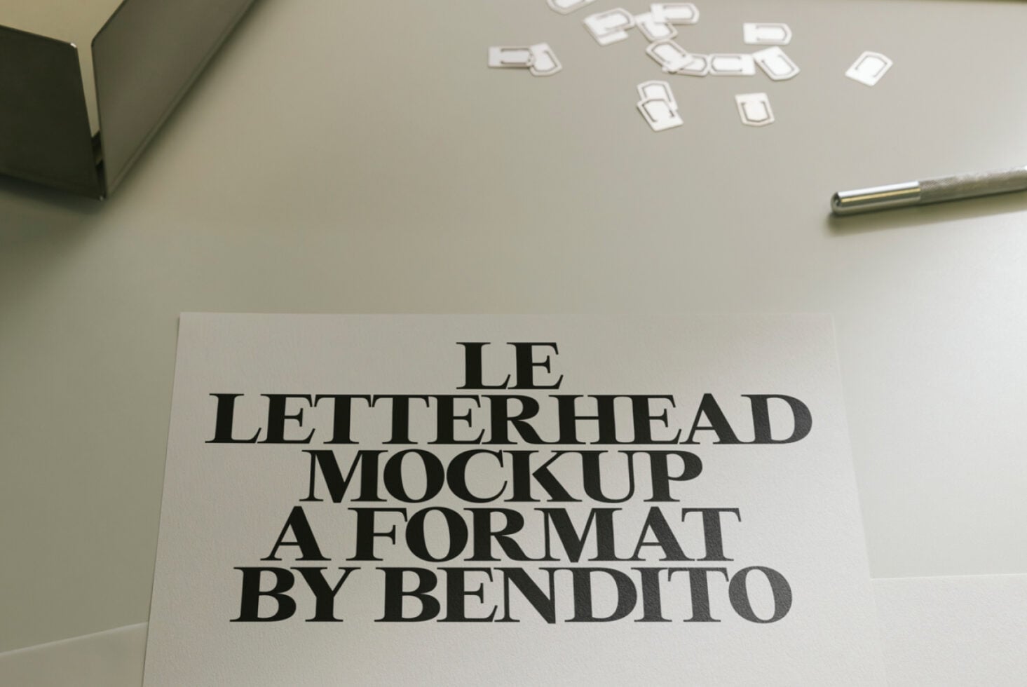White letterhead mockup with bold serif text displayed on minimalist workspace setup