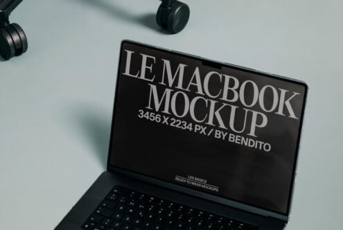 MacBook screen mockup open on minimal desk with headphones above