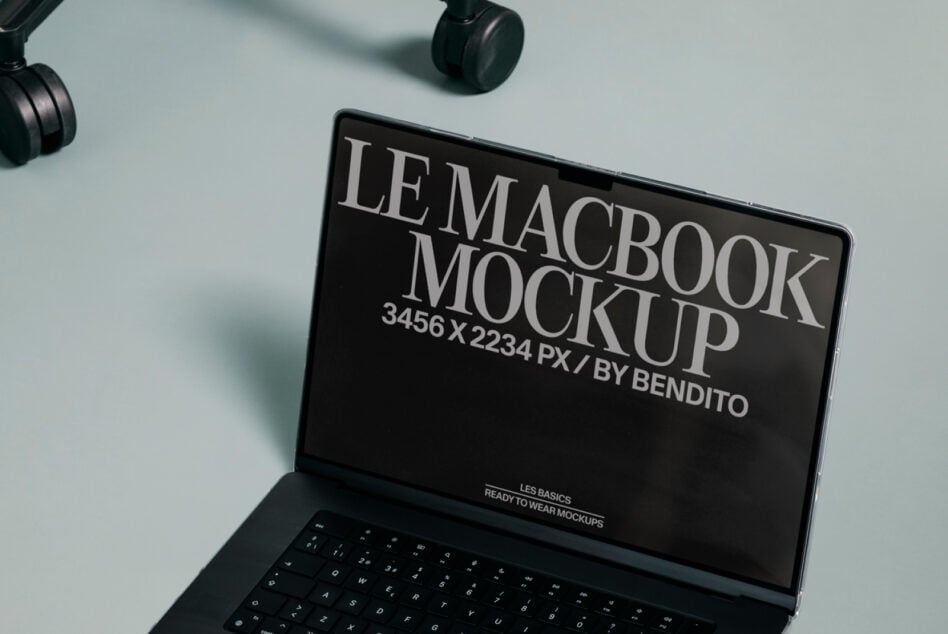 MacBook screen mockup open on minimal desk with headphones above