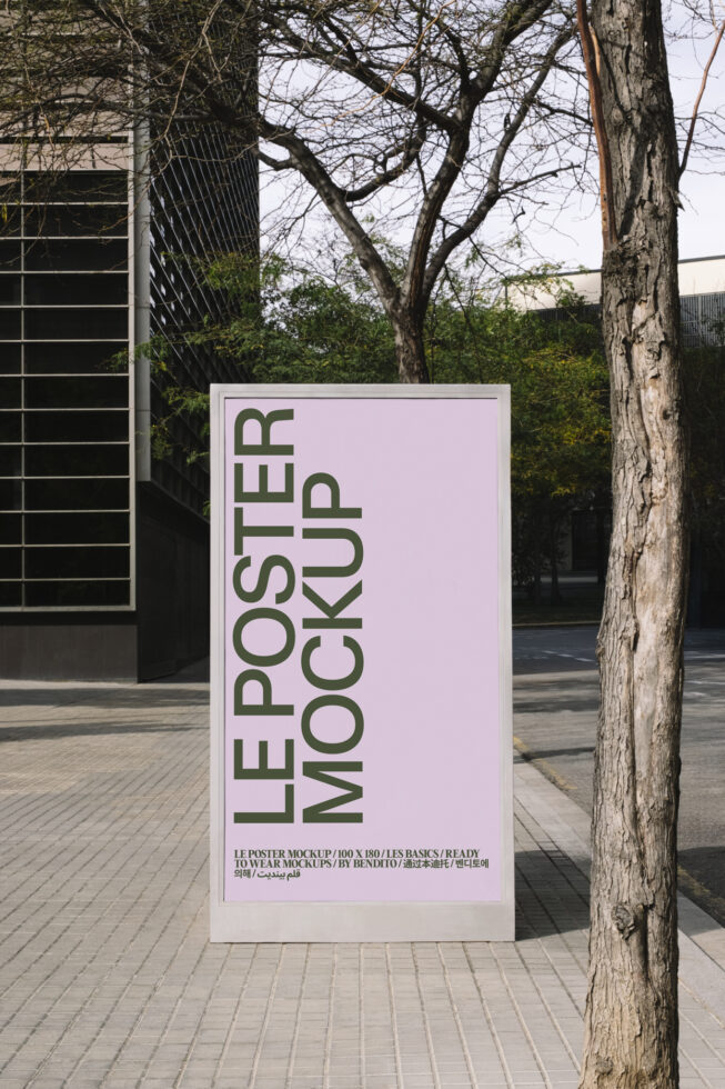 Pink poster mockup standing outdoors with bare tree in background