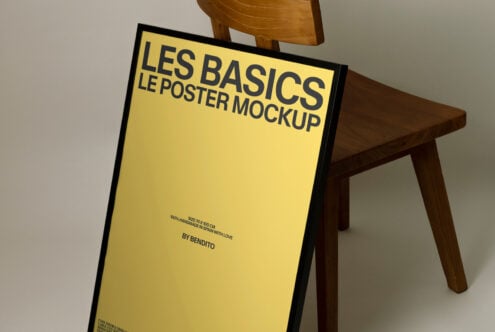 Yellow poster angled against wooden chair with Les Basics mockup text readable