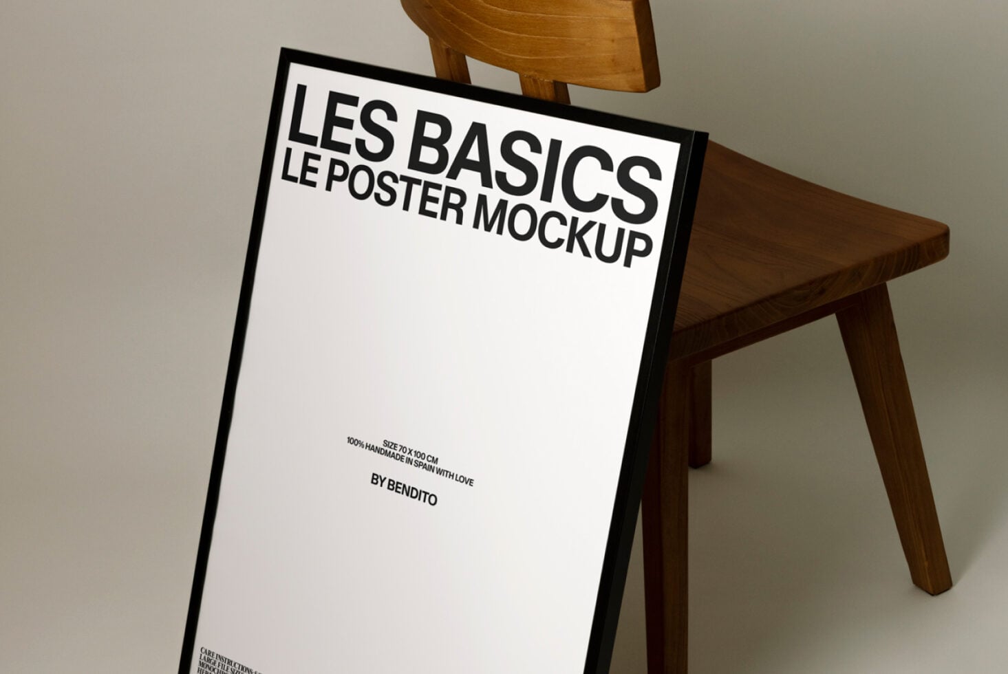 Poster mockup with black frame leaning against wooden chair in studio