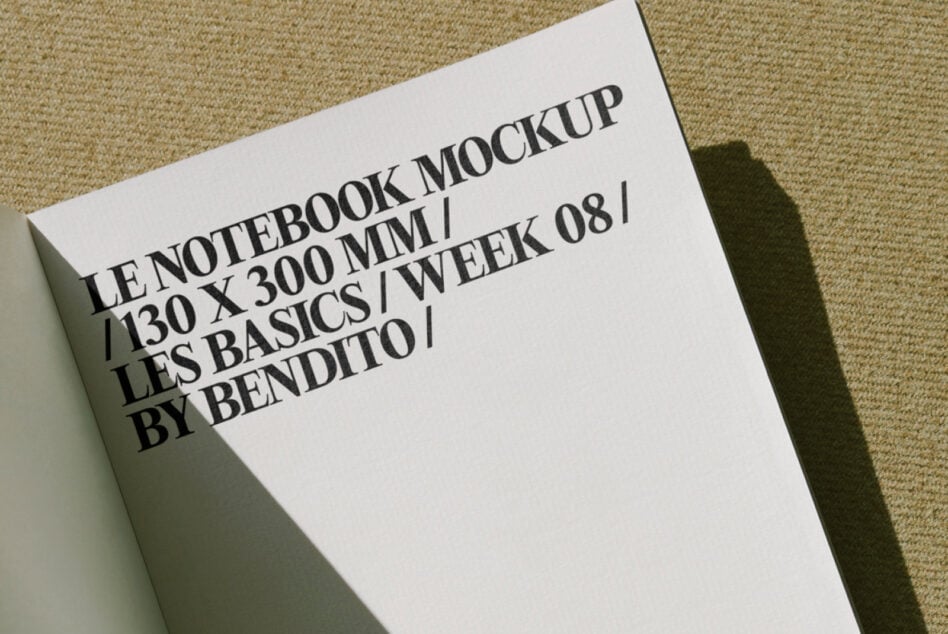 Off-white notebook mockup tilted on tan fabric with strong side shadow
