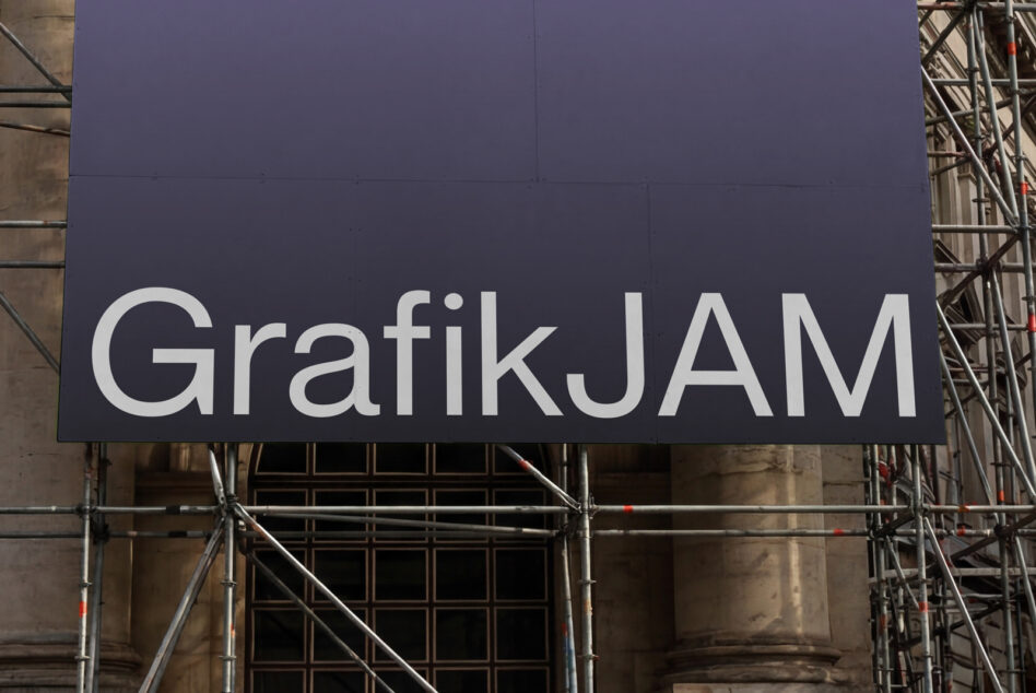 Navy blue construction billboard with white GrafikJAM text on facade