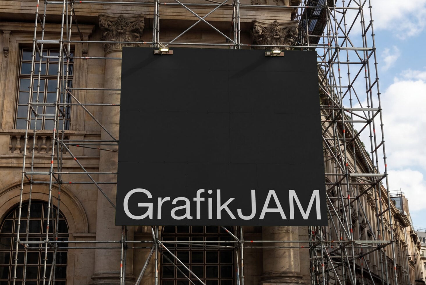 Black construction billboard with white GrafikJAM text on building facade