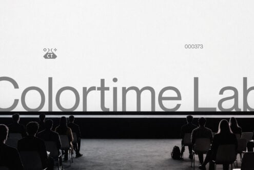 Large text on projection screen with audience seated facing it