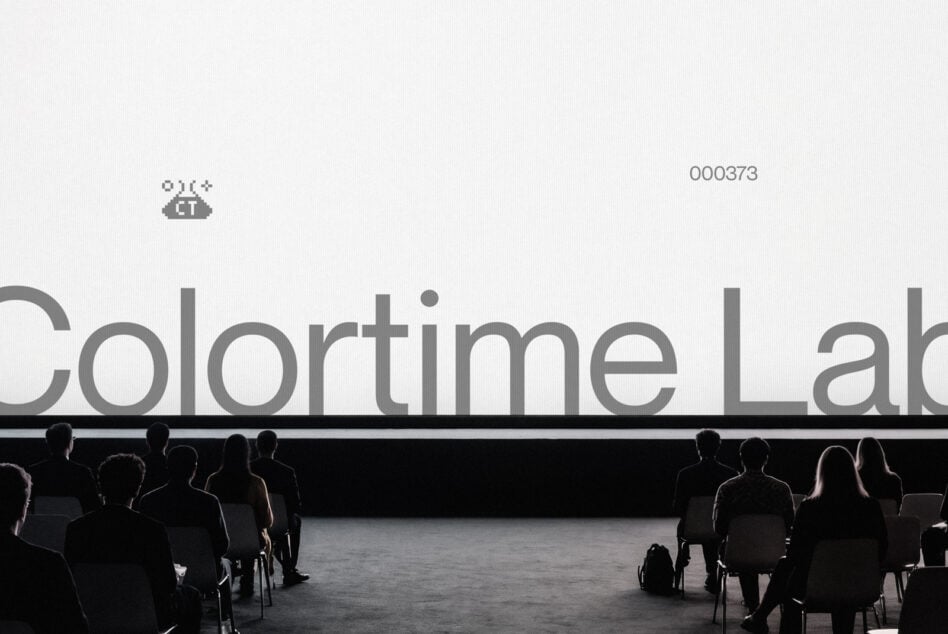 Large text on projection screen with audience seated facing it