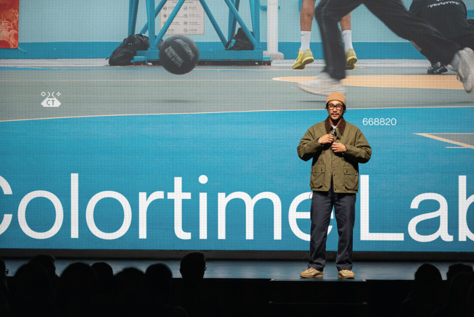 Speaker on stage with gym equipment overlay, colorful gradient backdrop