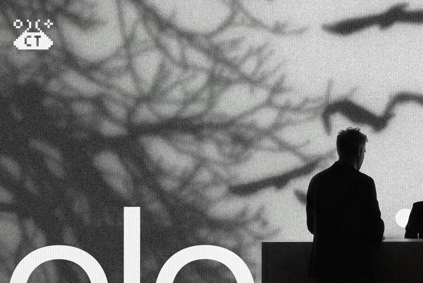 Black silhouette figure on stage with blurred crowd background, monochrome