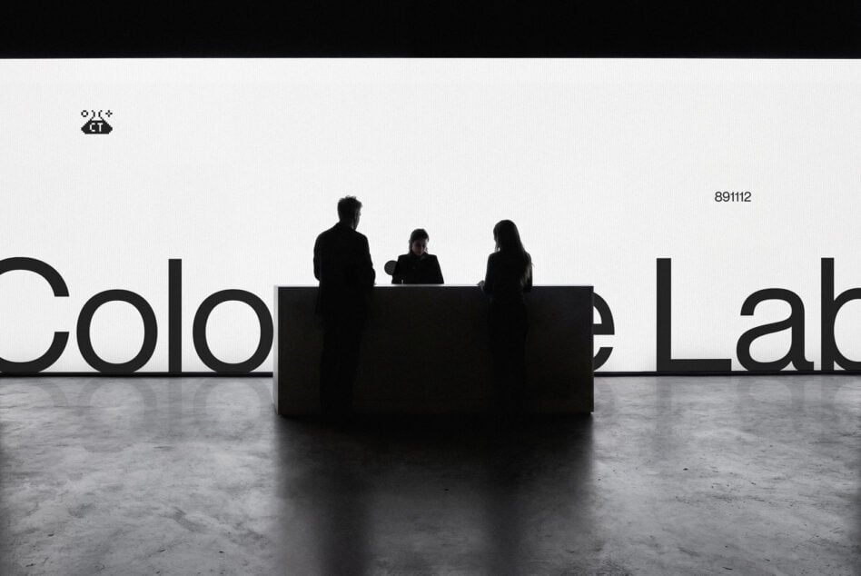 Three silhouetted figures sitting behind black desk with large partial text visible behind them