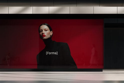 Red lit storefront billboard with portrait of person in black turtleneck