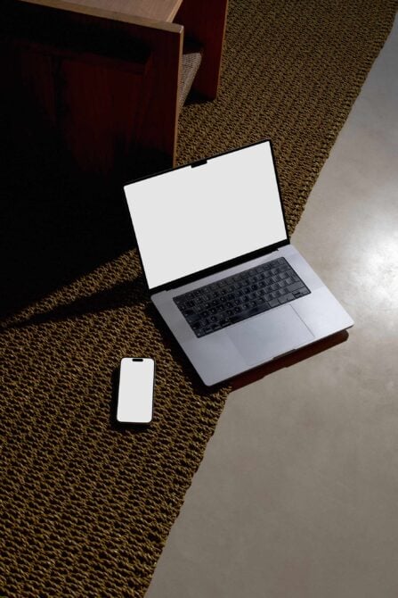 Laptop with blank screen, phone with blank screen on textured floor
